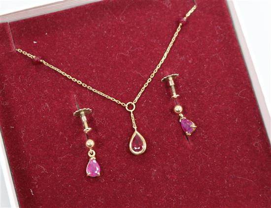 A ruby and 9ct gold pendant and a pair of earrings en suite, the pendant on 9ct gold fine chain with ruby spacers